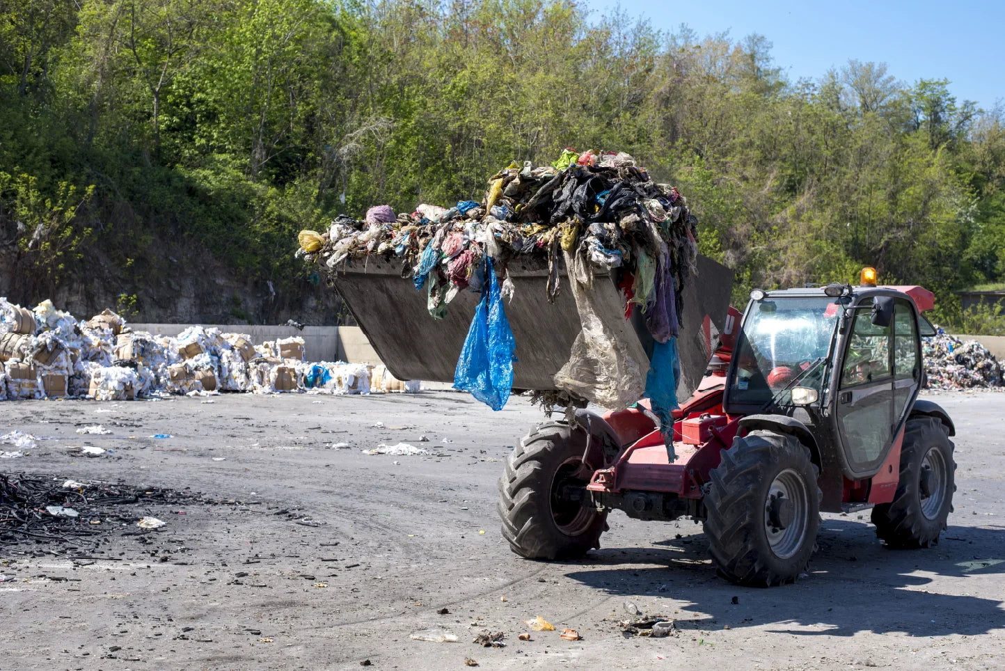A waste dump featuring plastic refuse and a dumper truck