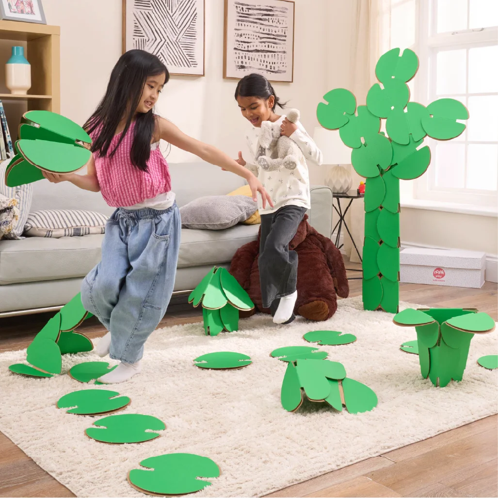 Two girls are playing in a living room, running around a magical scene made out of a noook play® building kit. The girls are jumping between trees and Lilly pads made of noook play® building discs and the girls are holding butterflies also made of noook play® building discs.
This Magic Garden took 49 noook play® discs to build.
