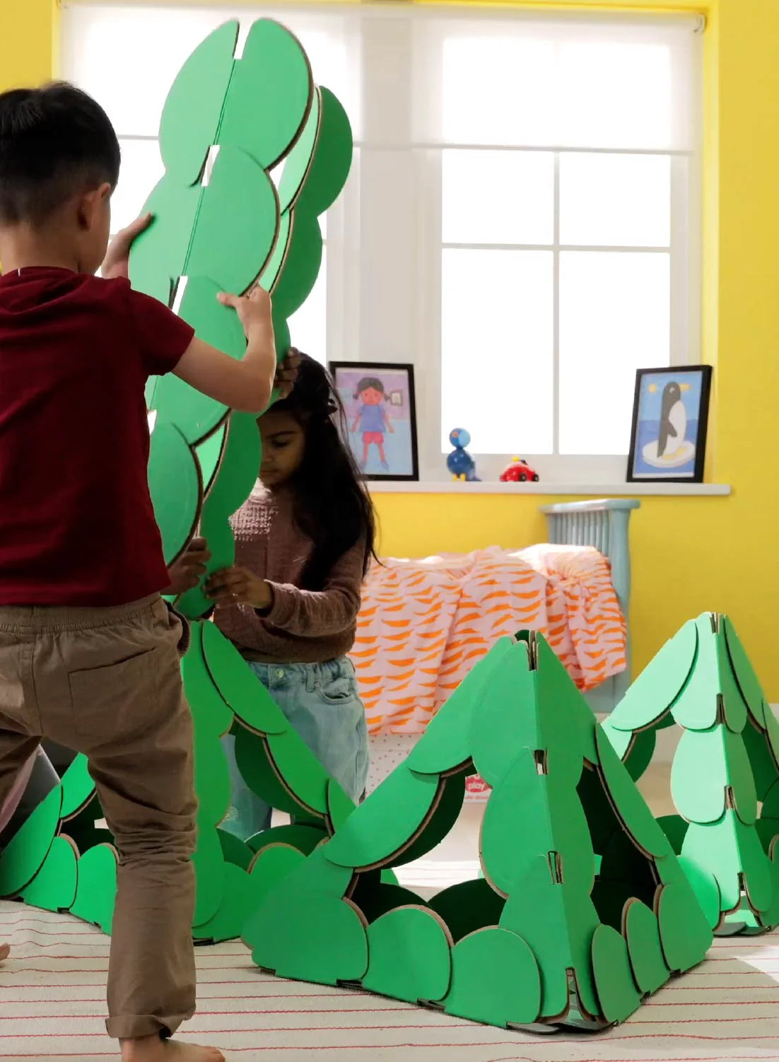 Children build pyramid structures with noook play® discs, exploring geometry, design, and teamwork