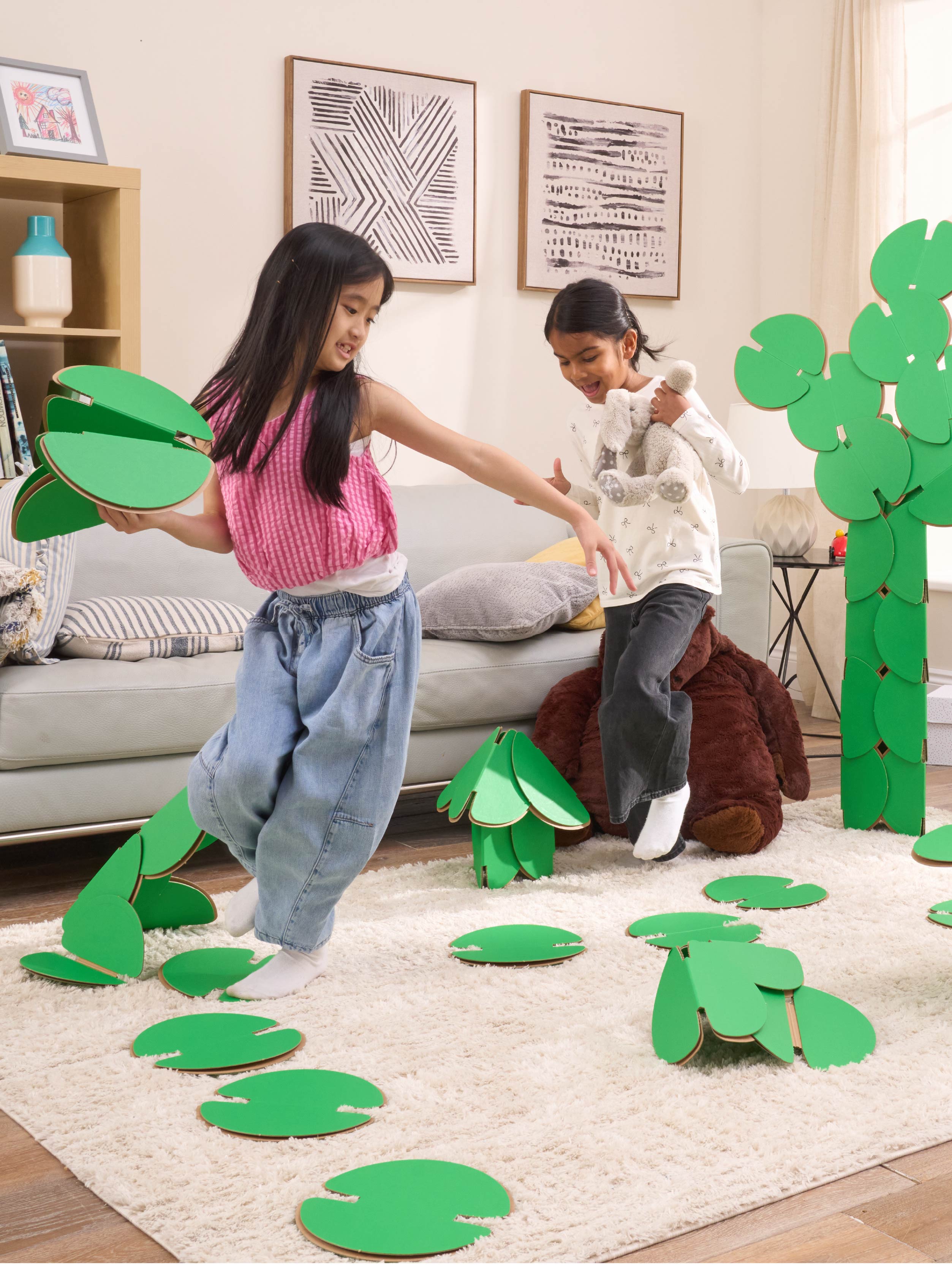 Two girls are playing in a living room, running around a magical scene made out of a noook play® building kit. The girls are jumping between trees and Lilly pads made of noook play® building discs and the girls are holding butterflies also made of noook play® building discs.
This Magic Garden took 49 noook play® discs to build.