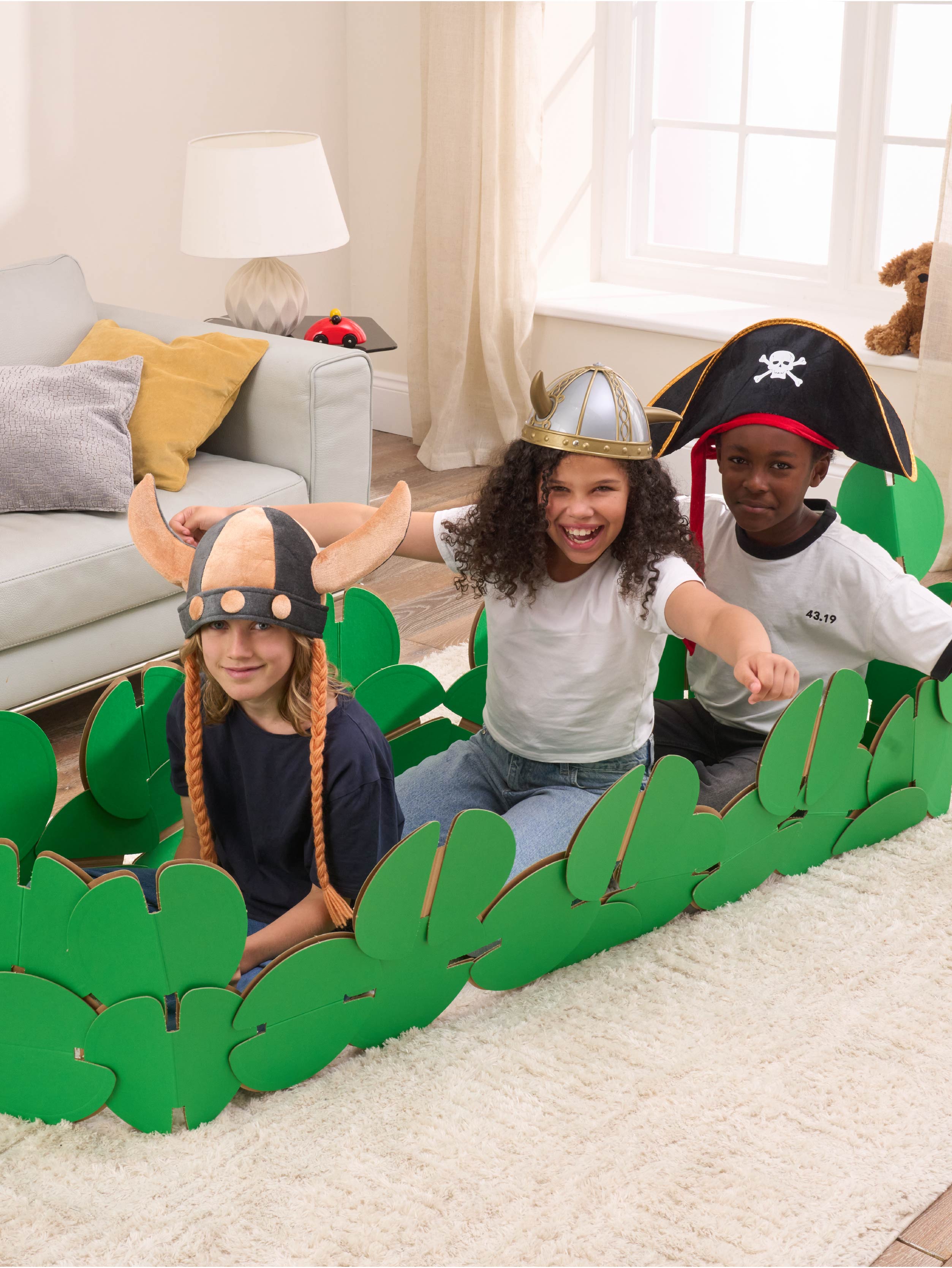 Three kids are playing in a sitting room, pretending to be Vikings on a raid. They're playing in a Viking longboat made of our a noook play® building kit. Two kids are wearing Viking horned helmets and one is wearing a Pirates' hat.
This Viking Longboat took 46 noook play® discs to build.
