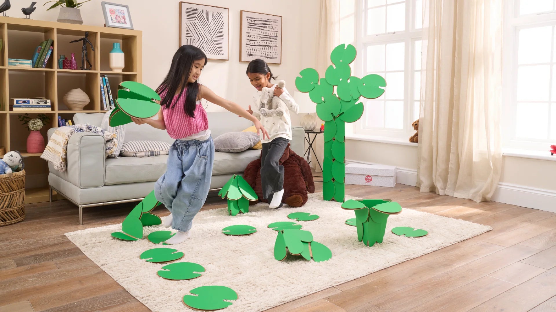 Two girls are playing in a living room, running around a magical scene made out of a noook play® building kit. The girls are jumping between trees and Lilly pads made of noook play® building discs and the girls are holding butterflies also made of noook play® building discs.
This Magic Garden took 49 noook play® discs to build.