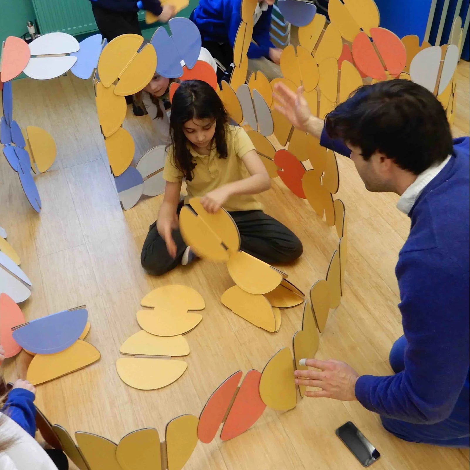 A school child building with noook play® discs, exploring creativity through hands-on architectural play