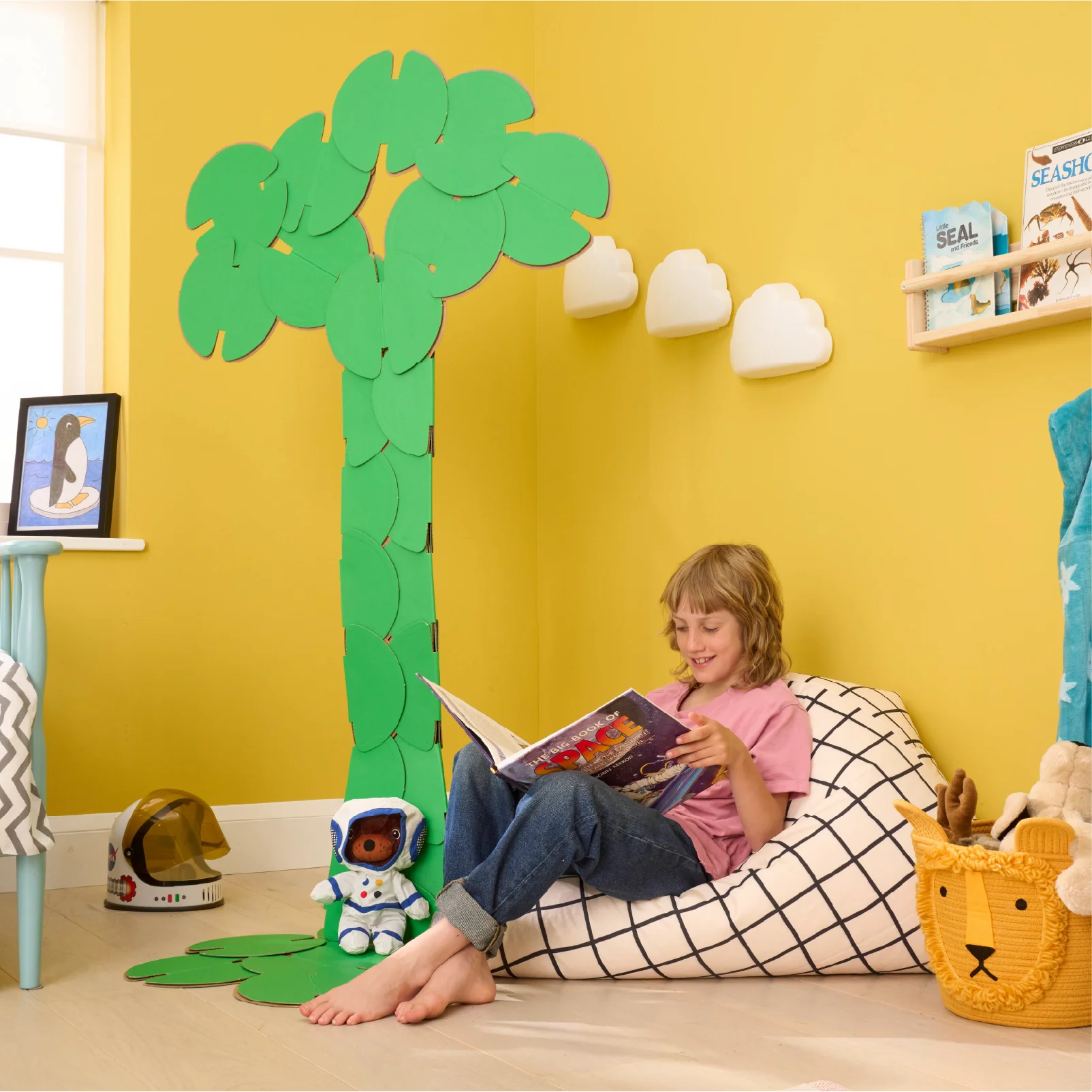 A boy reading a book in his bedroom, under a decoration made of noook play® building toys in the shape of the tree of life.
This Tree of Life took 36 noook play® discs to build.