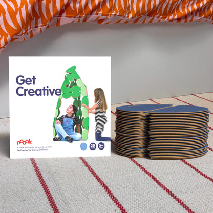 The noook play® Starter Pack, 30 Pieces, in blue, shown at the foot of a child bed, on a stripy rug