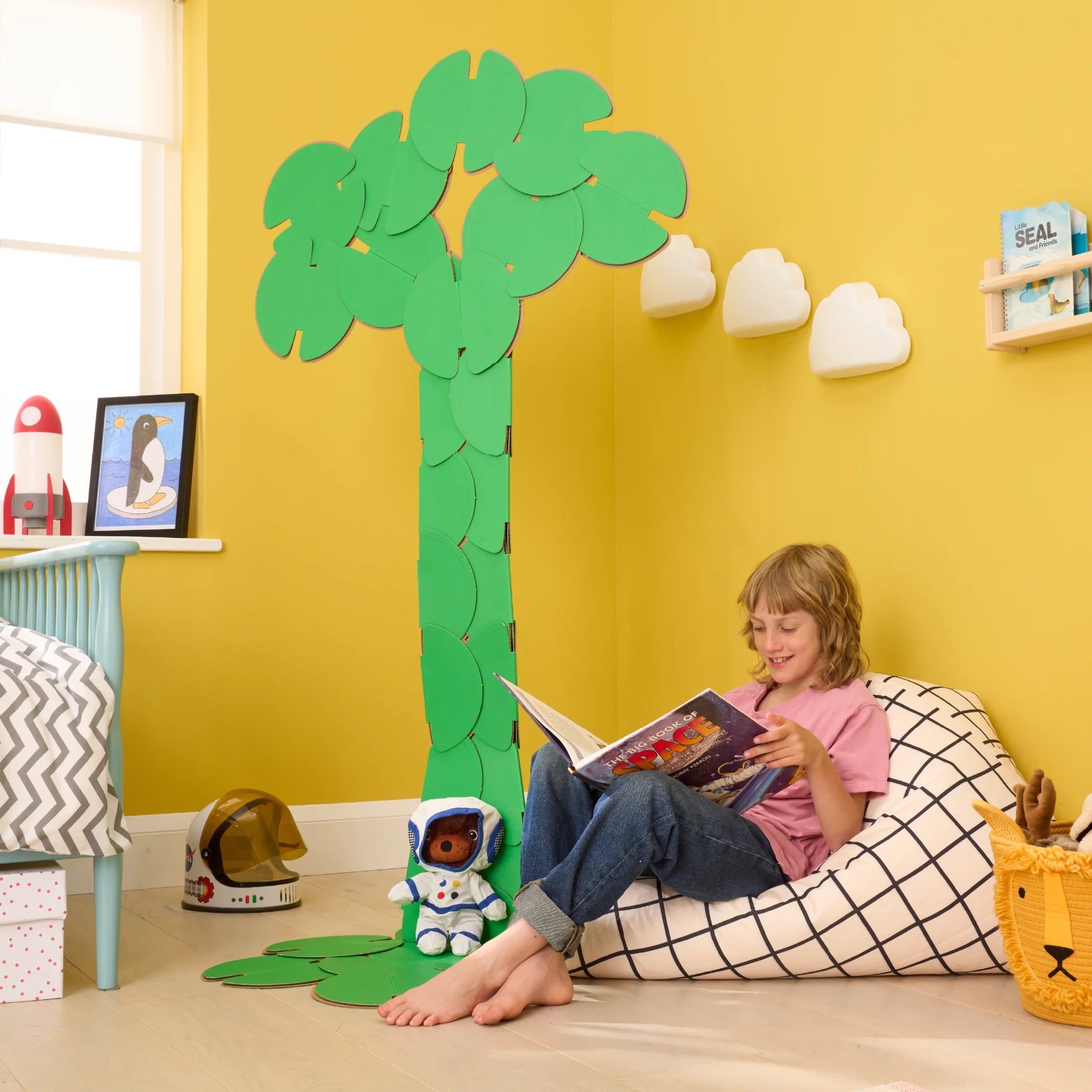 A boy reading a book in his bedroom, under a decoration made of noook play® building toys in the shape of the tree of life.
This Tree of Life took 36 noook play® discs to build.