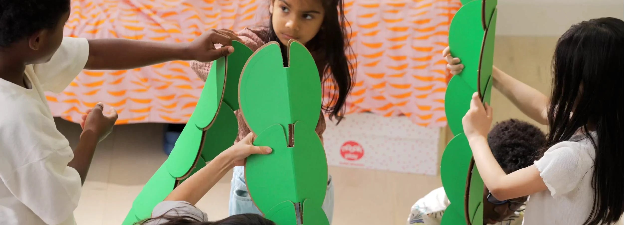 Children build pyramid structures with noook play® discs, exploring geometry, design, and teamwork