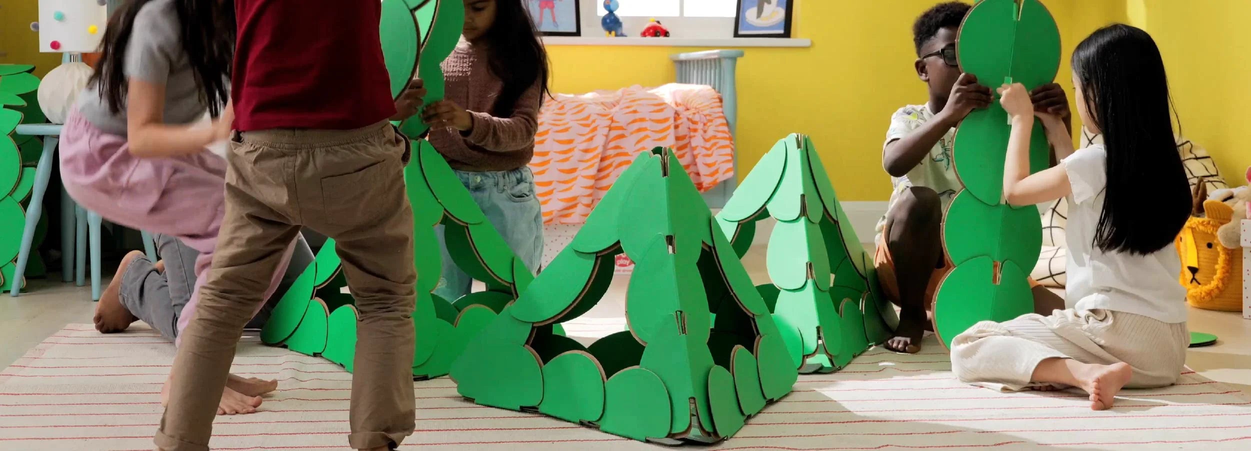 Children build pyramid structures with noook play® discs, exploring geometry, design, and teamwork