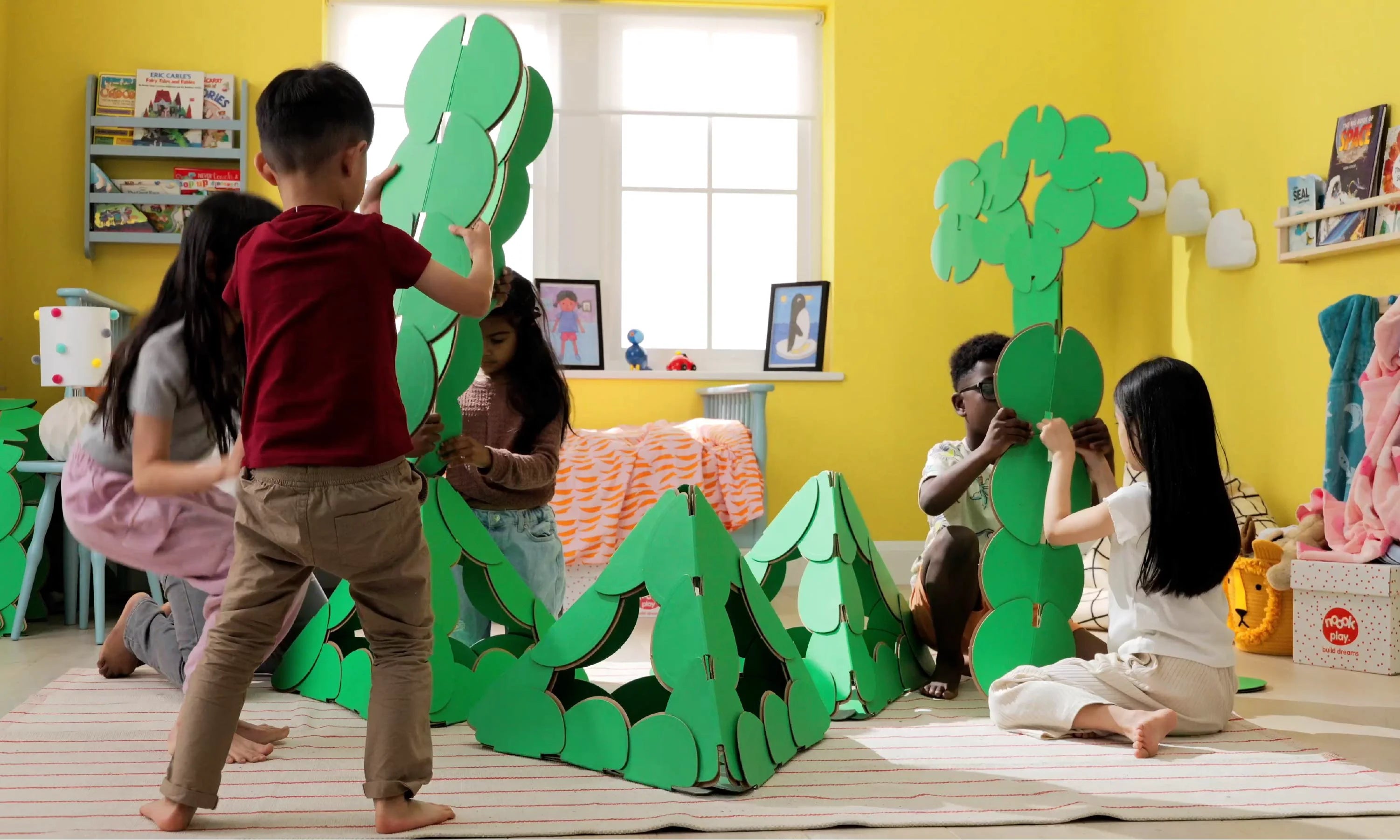 Children assemble pyramid shapes with noook play® discs, learning structure and collaboration