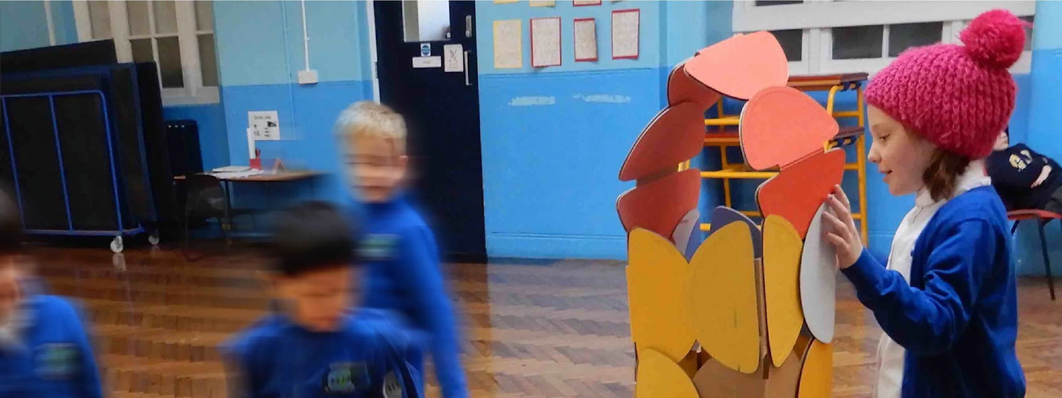 A group of school children building with noook play® discs, exploring creativity through hands-on architectural play