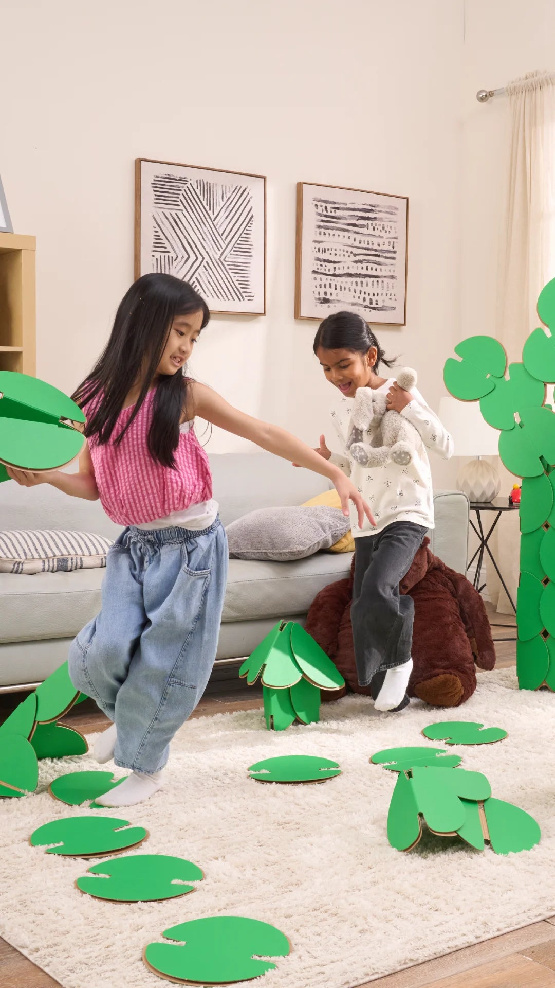 Two girls are playing in a living room, running around a magical scene made out of a noook play® building kit. The girls are jumping between trees and Lilly pads made of noook play® building discs and the girls are holding butterflies also made of noook play® building discs.
This Magic Garden took 49 noook play® discs to build.